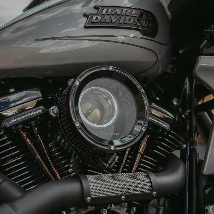 The Trask Assault Charge High-Flow Air Cleaner for Second Gen Harley-Davidson M8 features two round filters—chrome or black—with exposed red elements and visible mounting bolts, giving your bike&