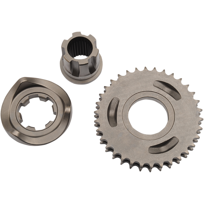 Three metal mechanical parts—a 34-tooth front sprocket with gear-like teeth and two distinctively shaped hubs from the Drag Specialties Compensating Sprocket Kit for 2006-2011 Harley-Davidson Big Twin—are displayed on a white background.