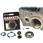 The James Super Nut Kit for 1936-1985 Big Twin with Chain Final Drive by James Gaskets is displayed next to a metal engine part, featuring a selection of gaskets, seals, and hardware components—including a four-speed transmission seal—neatly arranged on a white surface.
