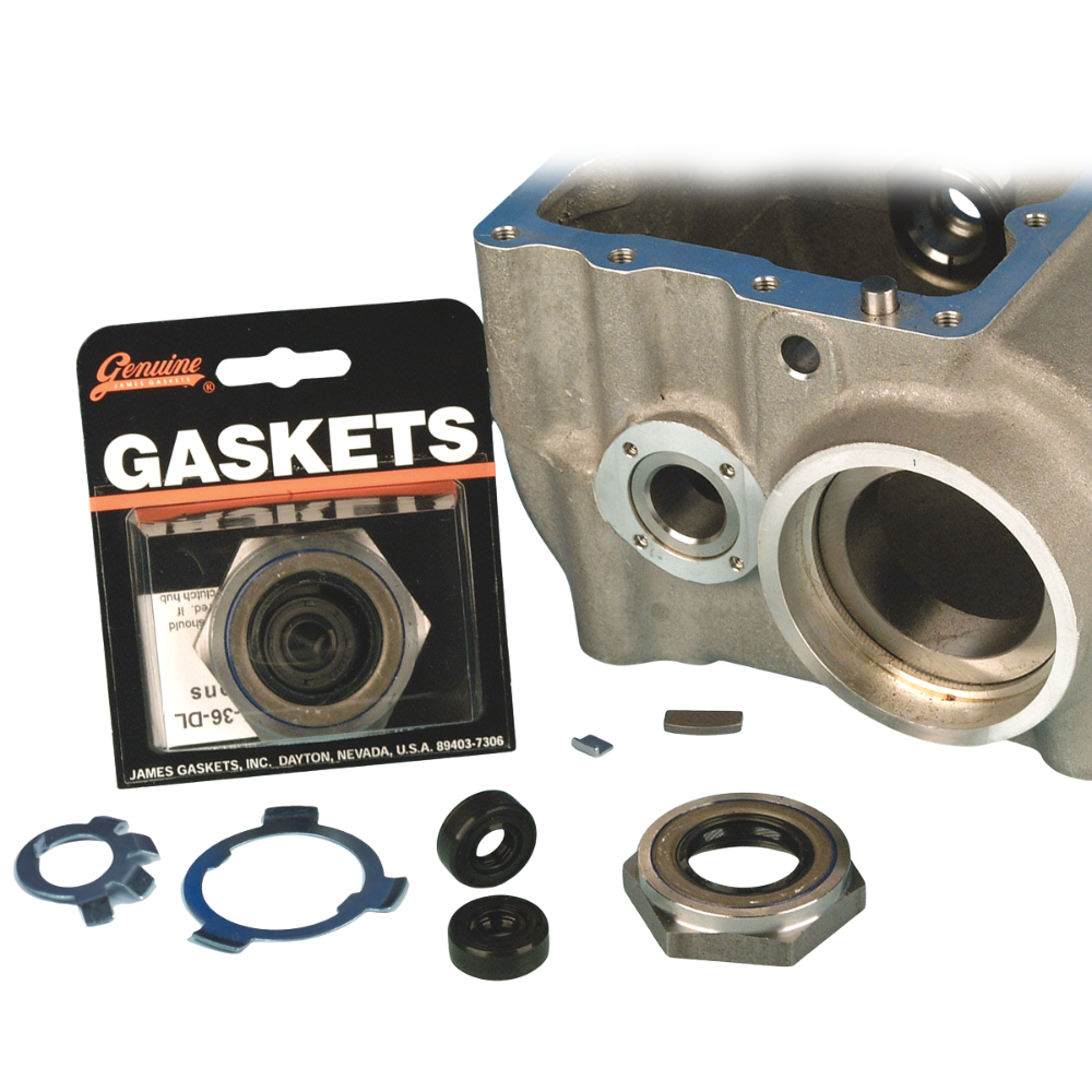 The James Super Nut Kit for 1936-1985 Big Twin with Chain Final Drive by James Gaskets is displayed next to a metal engine part, featuring a selection of gaskets, seals, and hardware components—including a four-speed transmission seal—neatly arranged on a white surface.