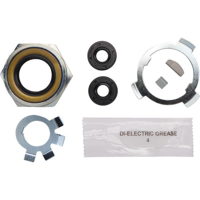 The James Super Nut Kit for 1936-1985 Big Twin with Chain Final Drive by James Gaskets is displayed next to a metal engine part, featuring a selection of gaskets, seals, and hardware components—including a four-speed transmission seal—neatly arranged on a white surface.