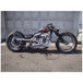A black Monster Craftsman motorcycle parked in front of a garage.