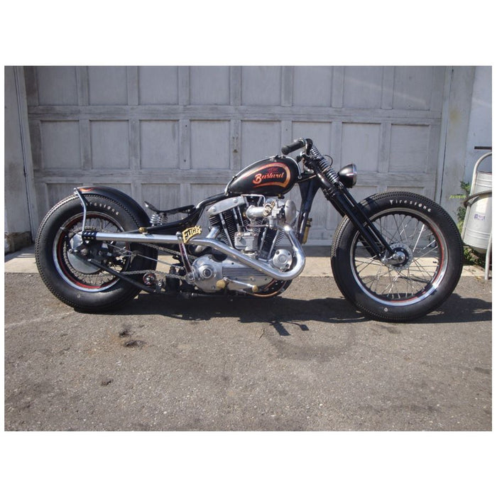 A Monster Craftsman Bolt On Chain Tensioner - Skate Wheel (Powell Peralta) motorcycle parked in front of a garage.