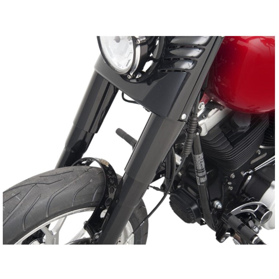 Close-up of a motorcycle's front suspension, tire, Drag Specialties Gloss Black Smooth Fork Slider Covers, and part of the engine.
