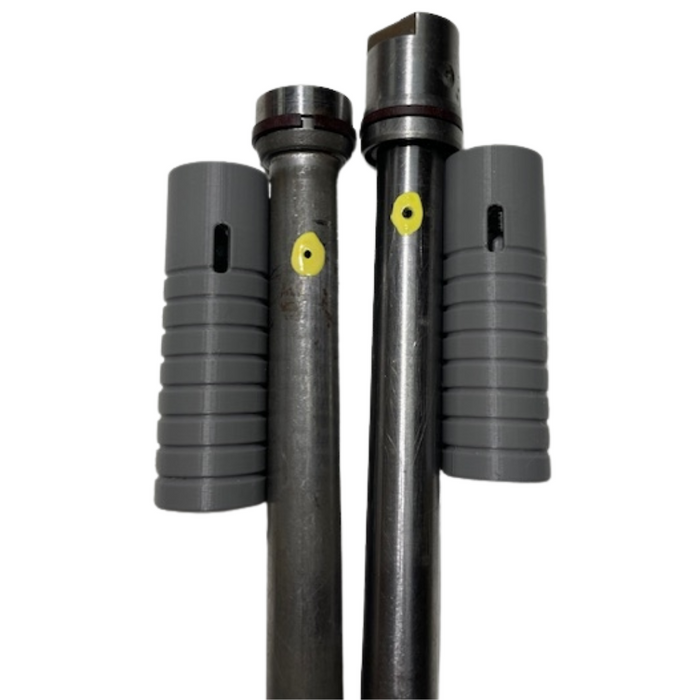 Two metal rods with grooves and yellow dots stand vertically, each flanked by a gray ridged sleeve—parts from the Hugh&