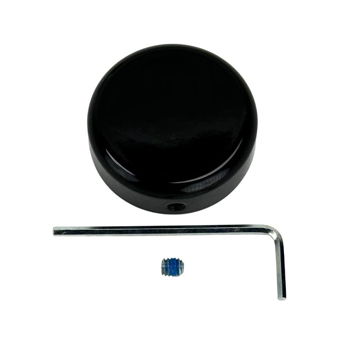 A round, black plastic object with a smooth, glossy finish and a small hole on its side—this Moto Iron® Steering Stem Bolt Cover for Harley-Davidson 39mm Narrowglide is photographed on a white background.