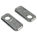 Two black and two silver rectangular plates with X-pattern engraving, plus two Handlebar Riser Bushings from the TC Bros. Handlebar Riser Bushing Conversion Kit, are arranged on a white background.