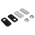 Two black and two silver rectangular plates with X-pattern engraving, plus two Handlebar Riser Bushings from the TC Bros. Handlebar Riser Bushing Conversion Kit, are arranged on a white background.