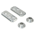Two black and two silver rectangular plates with X-pattern engraving, plus two Handlebar Riser Bushings from the TC Bros. Handlebar Riser Bushing Conversion Kit, are arranged on a white background.