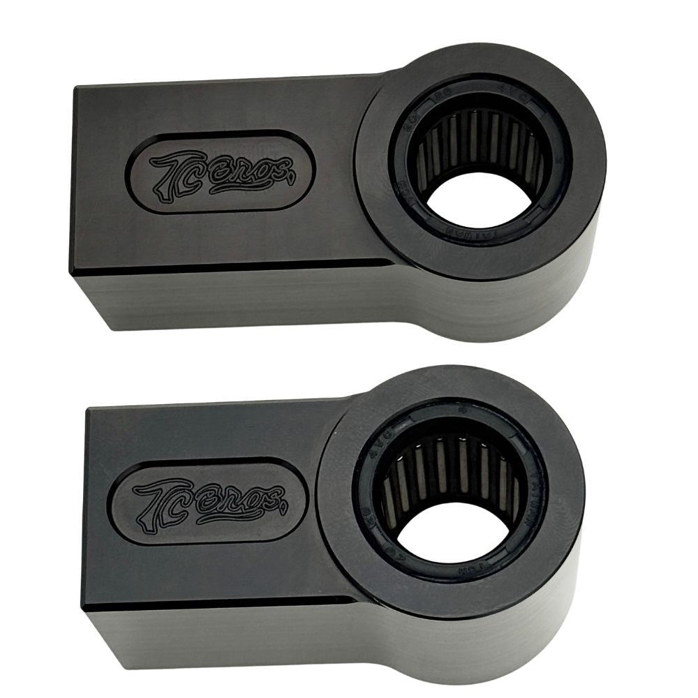 Two identical TC Bros. Shock Extensions for 2018-Up Harley-Davidson Softail, black metal with "TC Bros." engraving, shown side by side on a white background—perfect for upgrading your motorcycle suspension or lift kit.