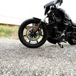 The TC Bros. Profile™ Front Floating Brake Rotor, compatible with 2023+ Harley Touring Bagger and 2021+ Pan America models, features a perforated round design crafted from high-carbon stainless steel with a black center and silver edge.