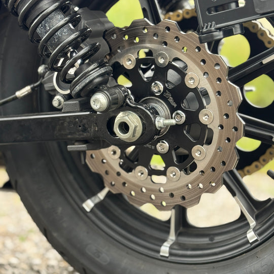 A close-up of the TC Bros. 10.25in Profile™ Rear Floating Brake Rotor, featuring a ventilated, perforated design with a black hub and silver ring—ideal for upgrading 2008-2022 Harley-Davidson Sportster brakes.