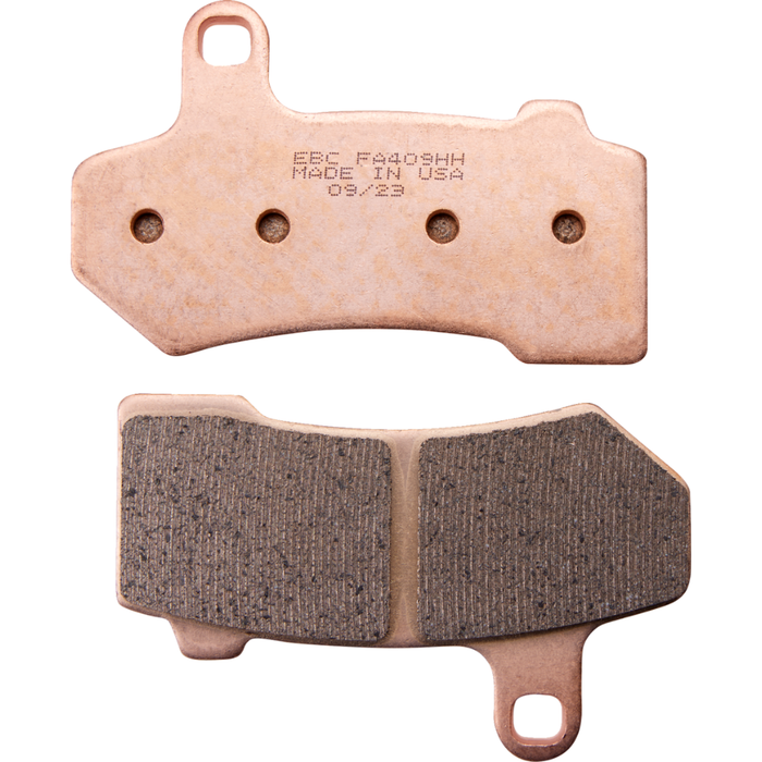 Two EBC Double-H Fully Sintered Brake Pads for 2008-2023 Harley-Davidson Touring, Trike, and V-Rod are shown—one with the friction surface visible, the other displaying the stamped model number and manufacturing details.
