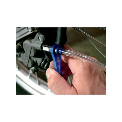 A person is using a Motion Pro mini brake bleeder with an 8mm nipple to tighten a tire on a motorcycle.