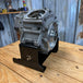 TC Bros. Engine Stand for 1999-2017 Harley Twin Cam A Motor (Touring & Dyna); black metal bracket with "TC BROS" cutout and multiple bolt holes—sturdy support for your engine.