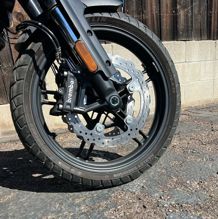 The TC Bros. Profile™ Front Floating Brake Rotor for 2024-up Harley Touring Bagger and 2021-up Pan America, crafted from stainless steel with edge holes and an irregular circular shape, mirrors the robust design of Harley Pan America&