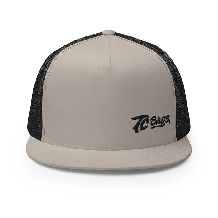 Beige and black TC Bros. Script Flat Bill Trucker Cap with "tecos" logo embroidery featuring snapback closure.