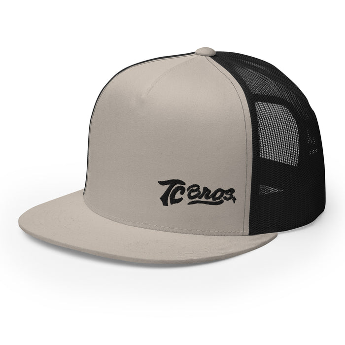 Beige and black TC Bros. Script Flat Bill Trucker Cap with "tecos" logo embroidery featuring snapback closure.