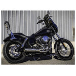 A black Bassani Dyna motorcycle with a Road Rage Ripper 2 into1 Stainless Exhaust "Super Bike" Muffler for 2006-2017 Dyna parked in front of a metal building.