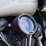Close-up of a Trask Assault Charge High-Flow Air Cleaner for TBW Harley-Davidson Twin Cam, by Trask, featuring a black metal housing and a visible red pleated filter element.