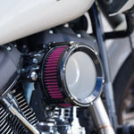 Close-up of a Trask Assault Charge High-Flow Air Cleaner for TBW Harley-Davidson Twin Cam, by Trask, featuring a black metal housing and a visible red pleated filter element.