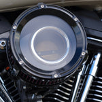 Close-up of a Trask Assault Charge High-Flow Air Cleaner for TBW Harley-Davidson Twin Cam, by Trask, featuring a black metal housing and a visible red pleated filter element.
