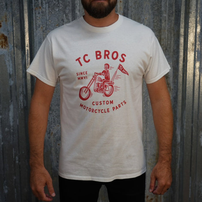 TC Bros. Rider - White Tee with red graphic of a motorcycle rider and text "TC Bros since MMVI custom motorcycle parts," printed on demand.