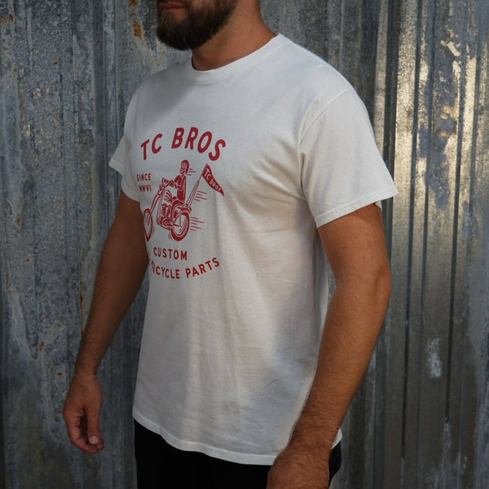 TC Bros. Rider - White Tee with red graphic of a motorcycle rider and text "TC Bros since MMVI custom motorcycle parts," printed on demand.