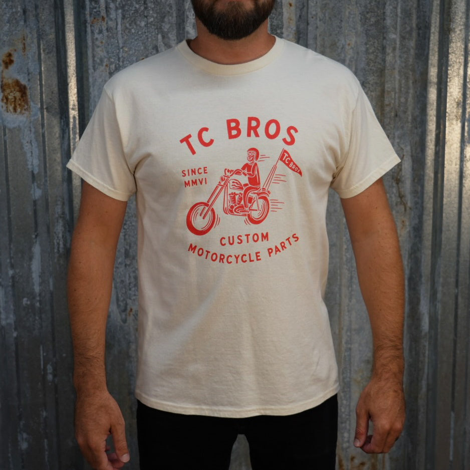 TC Bros. Rider - White Tee with red graphic of a motorcycle rider and text "TC Bros since MMVI custom motorcycle parts," printed on demand.