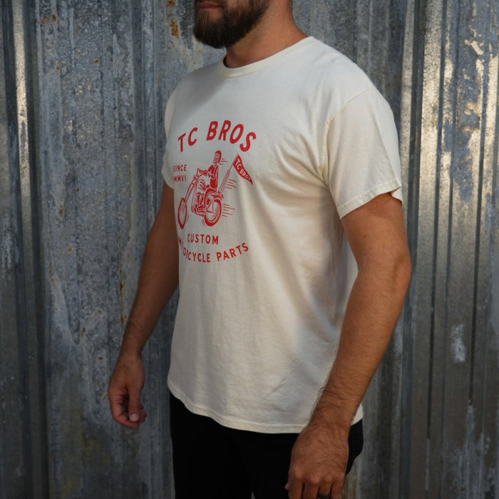 TC Bros. Rider - White Tee with red graphic of a motorcycle rider and text "TC Bros since MMVI custom motorcycle parts," printed on demand.