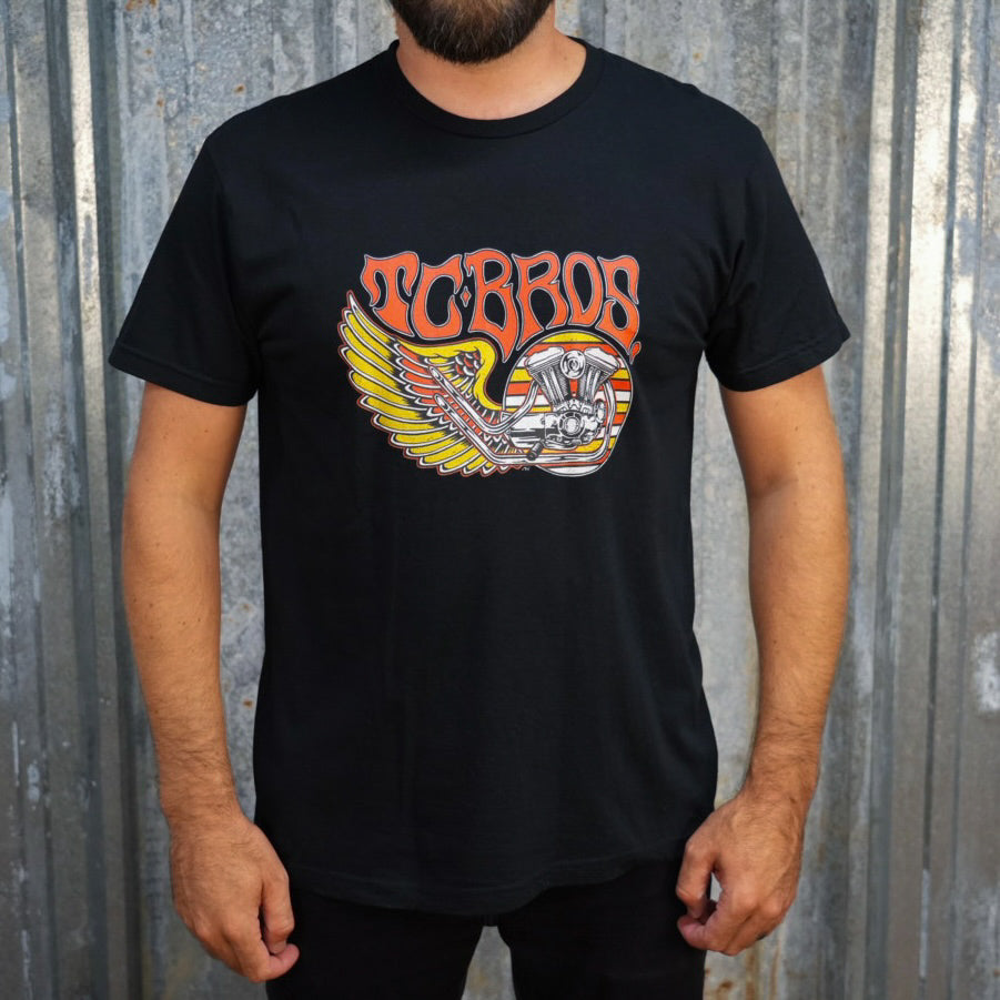 TC Bros. Wing Tee - Black, crafted from ring-spun cotton, with a graphic print featuring stylized wings, a motorcycle engine, and the text "turbos" in a flame-inspired font.