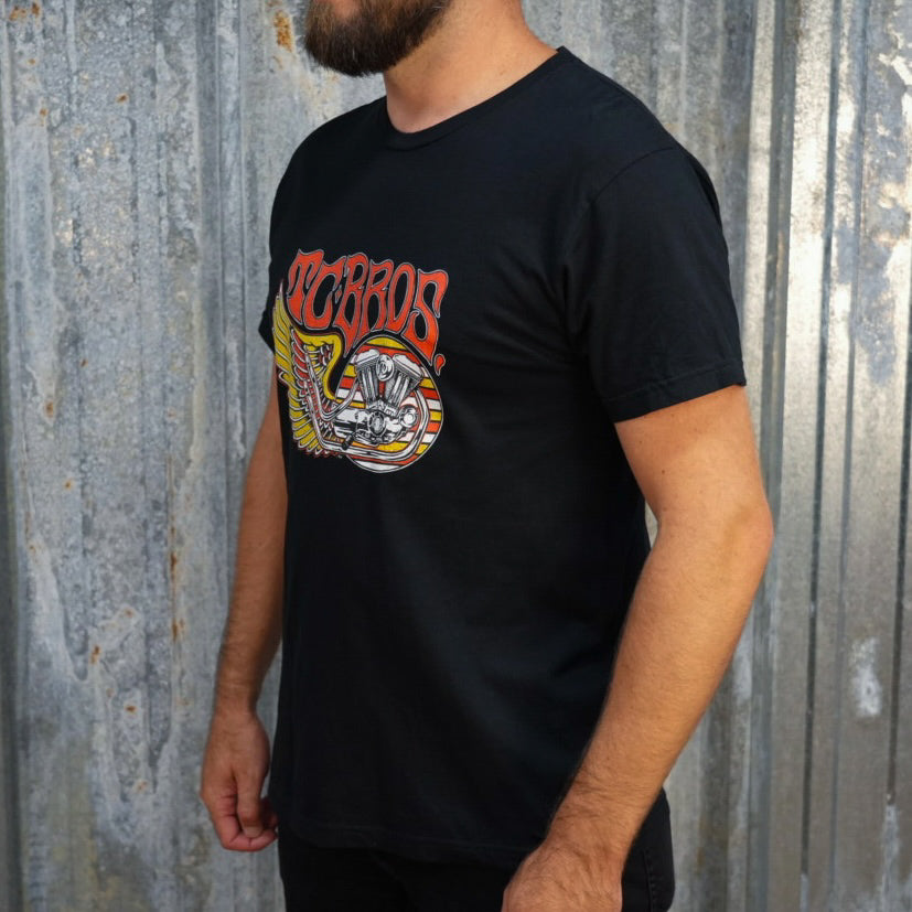 TC Bros. Wing Tee - Black, crafted from ring-spun cotton, with a graphic print featuring stylized wings, a motorcycle engine, and the text "turbos" in a flame-inspired font.