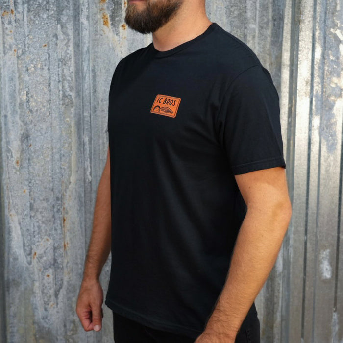 Badge - Black Tee, ring-spun cotton, with a small TC Bros. logo on the left chest area.