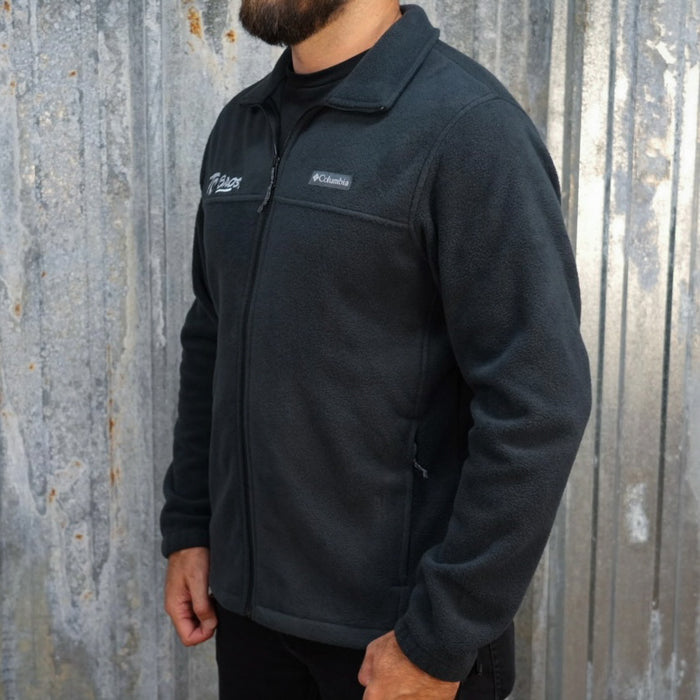 TC Bros. fleece zip jacket - Black with a high collar and zippered front, featuring white embroidered logos on the left chest.