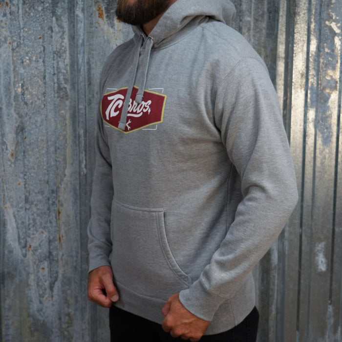 Carbon Gray TC Bros. Shield Hoodie with a red and white "tecos" logo on the front.