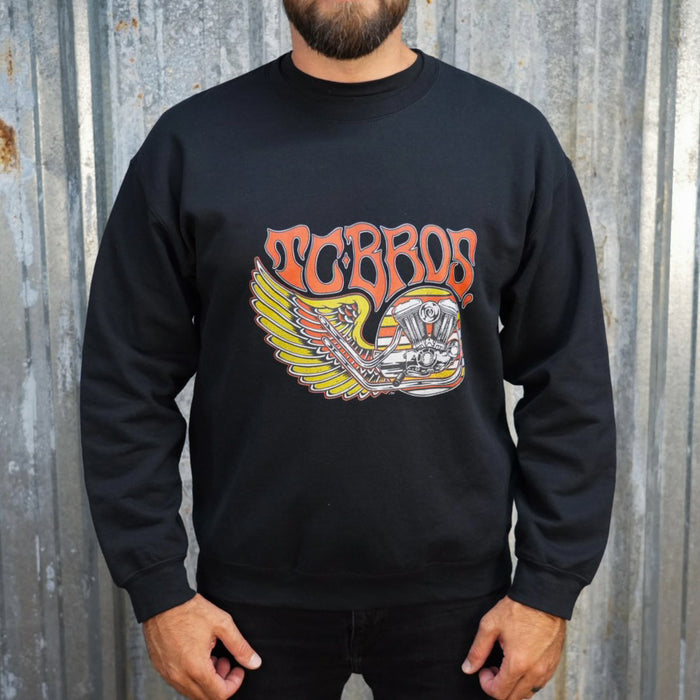 Wing Crewneck Sweatshirt - Black from TC Bros. with a motorcycle-themed graphic design featuring the text "turbos" and an illustration of a winged motorcycle engine. This classic fit sweater ensures warmth and style, printed on demand for