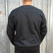 Wing Crewneck Sweatshirt - Black from TC Bros. with a motorcycle-themed graphic design featuring the text "turbos" and an illustration of a winged motorcycle engine. This classic fit sweater ensures warmth and style, printed on demand for