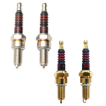 Two gold-colored Drag Specialties Spark Plugs for Harley-Davidson M8 and XG with black insulators and red rings.