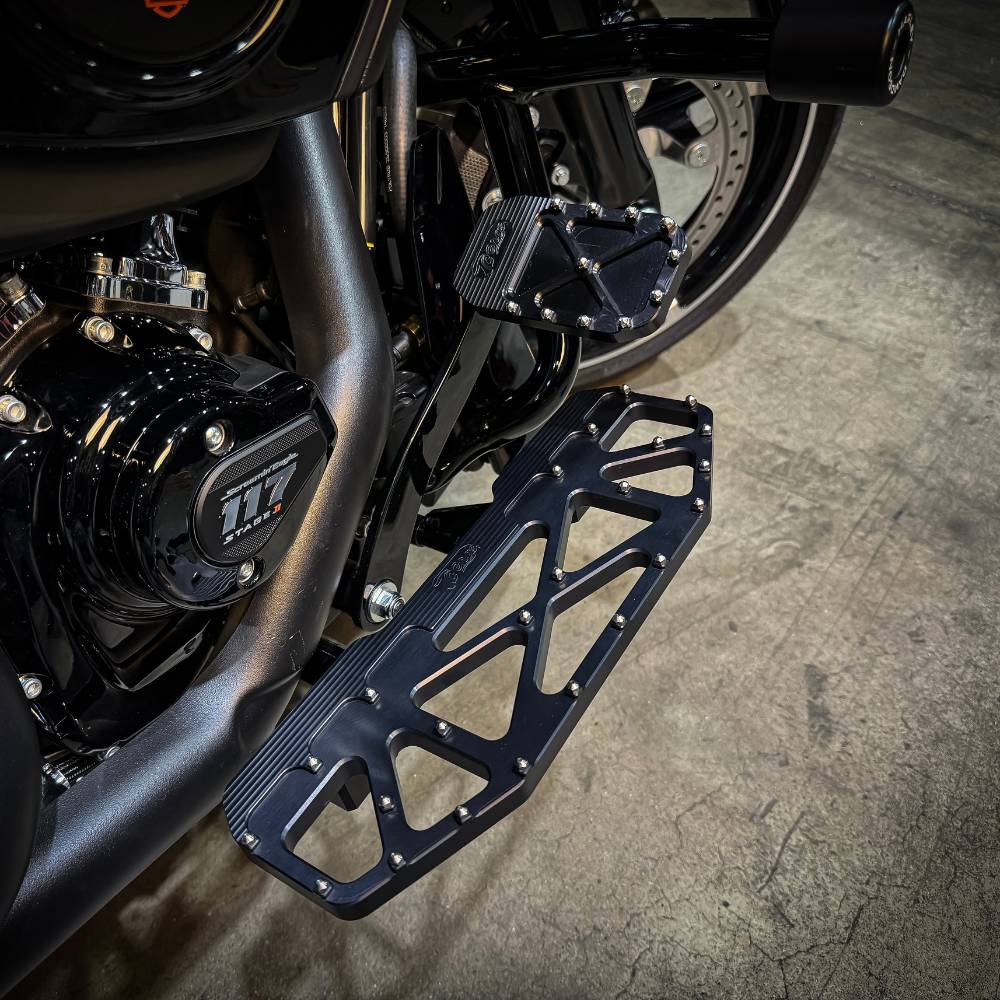 Three TC Bros. Pro Series MX Floorboards for Harley Davidson Bagger Touring Models with metallic finishes in silver, black, and gold featuring triangular cutout designs.