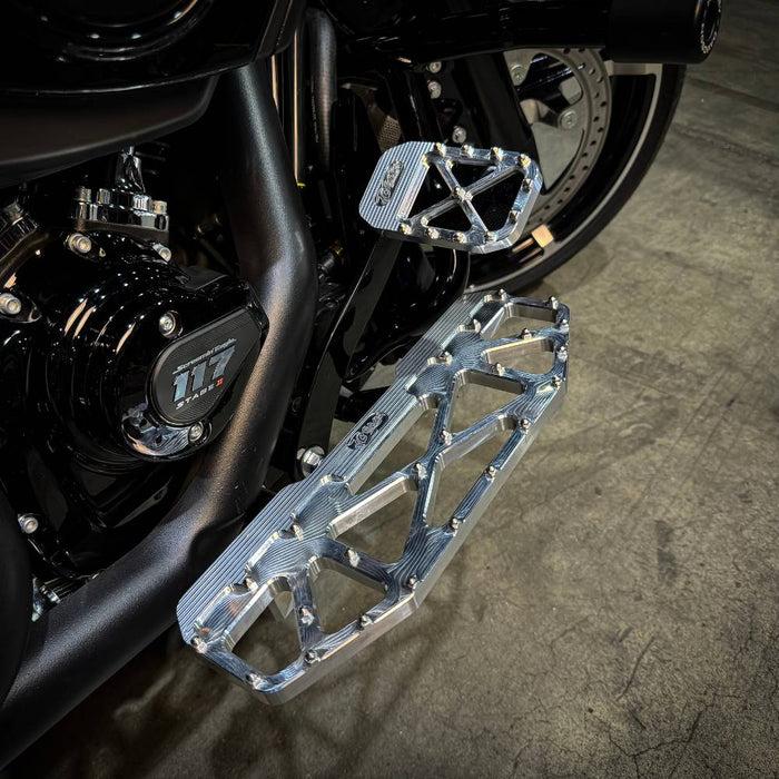 Three TC Bros. Pro Series MX Floorboards for Harley Davidson Bagger Touring Models with metallic finishes in silver, black, and gold featuring triangular cutout designs.