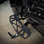 Close-up of TC Bros. Pro Series MX Floorboards for 1984-Up Harley-Davidson Touring, featuring billet aluminum footboards with geometric cutout designs on a concrete floor.