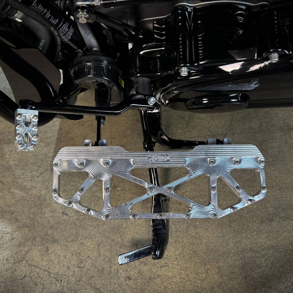 Three TC Bros. Pro Series MX Floorboards for Harley Davidson Bagger Touring Models with metallic finishes in silver, black, and gold featuring triangular cutout designs.