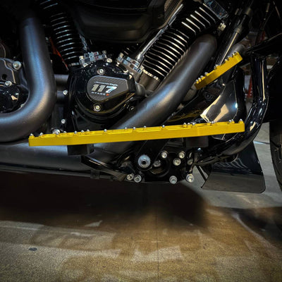 Three TC Bros. Pro Series MX Floorboards for Harley Davidson Bagger Touring Models with metallic finishes in silver, black, and gold featuring triangular cutout designs.