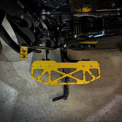 Three TC Bros. Pro Series MX Floorboards for Harley Davidson Bagger Touring Models with metallic finishes in silver, black, and gold featuring triangular cutout designs.