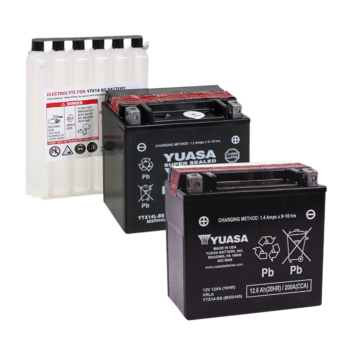 Three Yuasa YTX14/YTX14L batteries, including two black sealed AGM batteries in the foreground, and one electrolyte container with visible warning labels in the background.