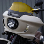 The Shark Demon™ 2 Performance LED Headlight Kit by Custom Dynamics is a round, black, DOT compliant headlight with an attached wiring harness and connectors. It also includes a separate mounting bracket with screws and rubber grommets, making it perfect for those seeking a reliable upgrade for their '22-'24 Harley Low Rider ST.