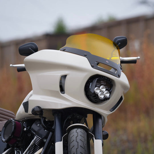 The Shark Demon™ 2 Performance LED Headlight Kit by Custom Dynamics is a round, black, DOT compliant headlight with an attached wiring harness and connectors. It also includes a separate mounting bracket with screws and rubber grommets, making it perfect for those seeking a reliable upgrade for their '22-'24 Harley Low Rider ST.