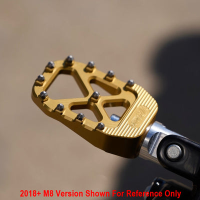 A TC Bros. Pro Series Gold MX Foot Pegs for Harley Davidson Models on a motorcycle ridden by a Harley Davidson rider.
