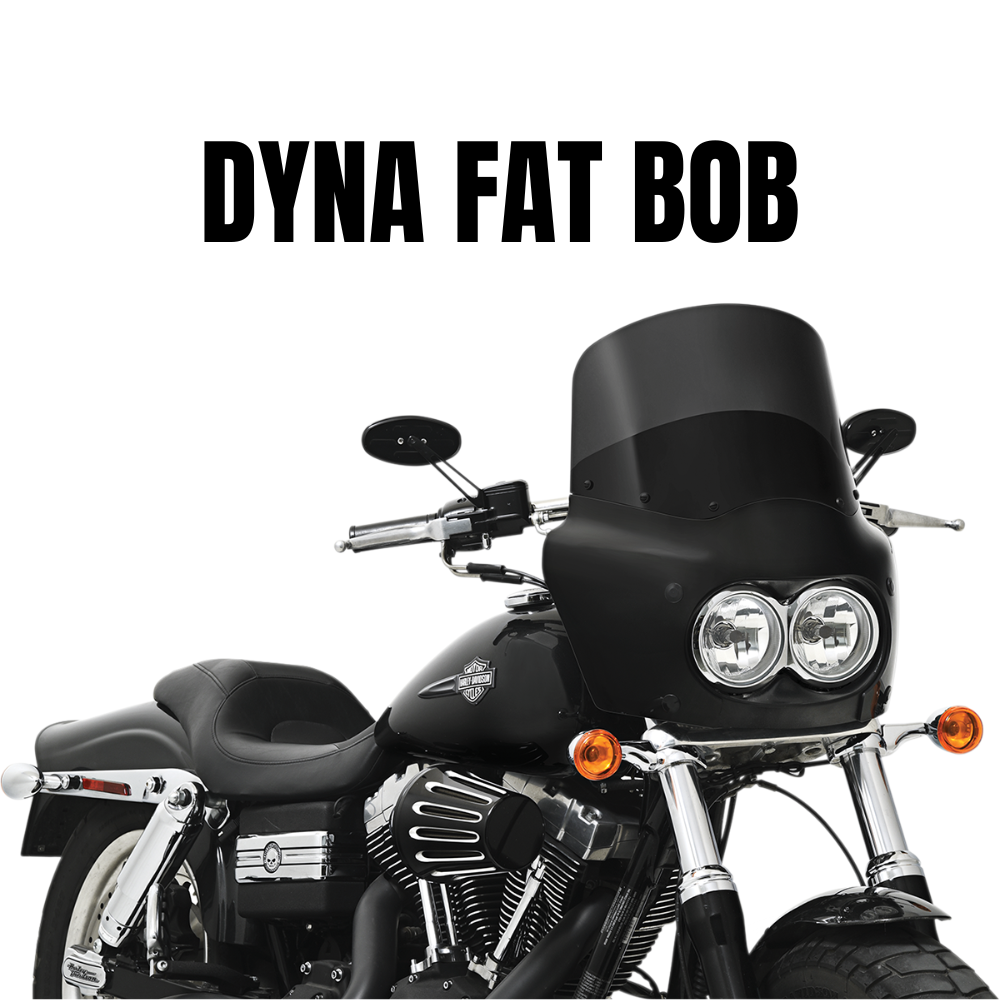 A black 2008-2017 Harley-Davidson Dyna Fat Bob with Memphis Shades Road Warrior Fairing and dual headlights is shown from the front-side. Text above reads “DYNA FAT BOB.”.