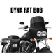 A black 2008-2017 Harley-Davidson Dyna Fat Bob with Memphis Shades Road Warrior Fairing and dual headlights is shown from the front-side. Text above reads “DYNA FAT BOB.”.